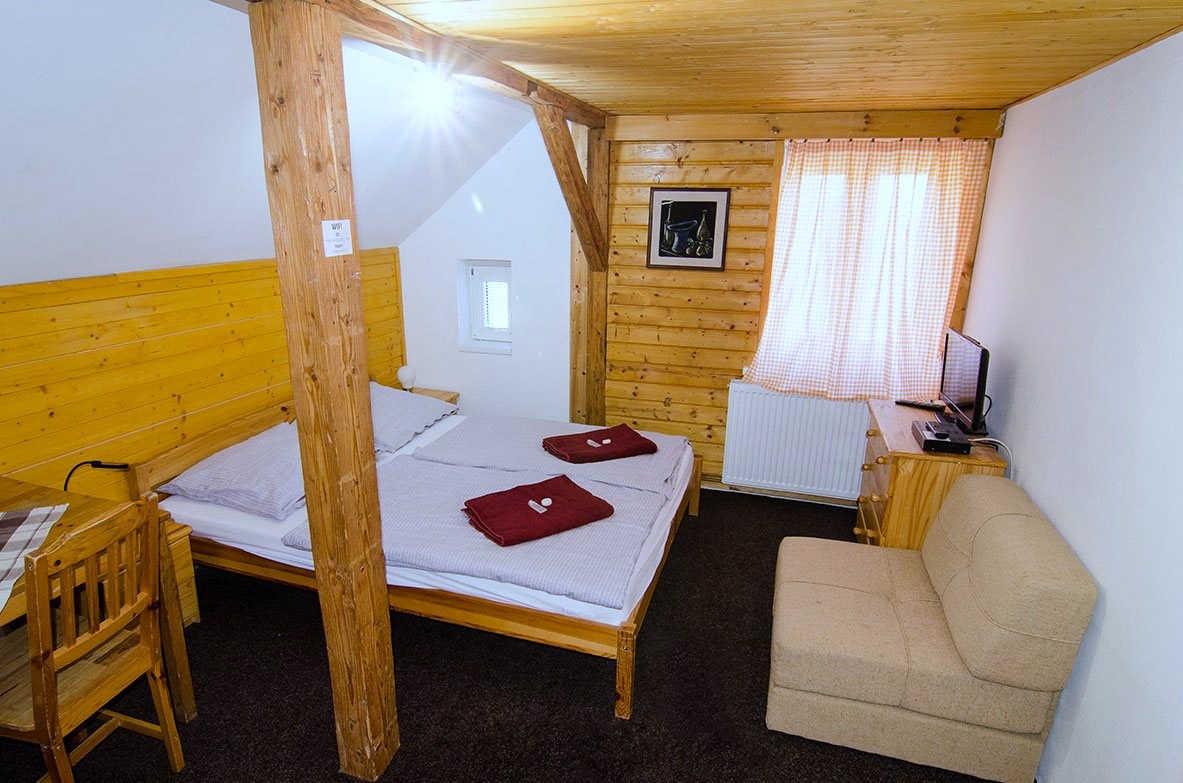 Pokoj č. 5 — manželská postel s růžovými závěsy